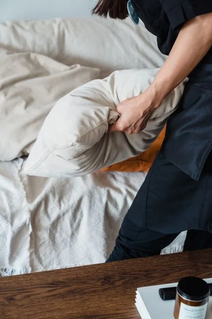 Person using spray bottle and cloth for cleaning a kitchen shelf, ensuring hygiene and cleanliness.